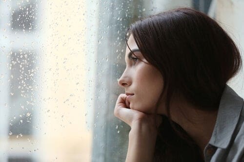 mujer triste mirando por la ventana
