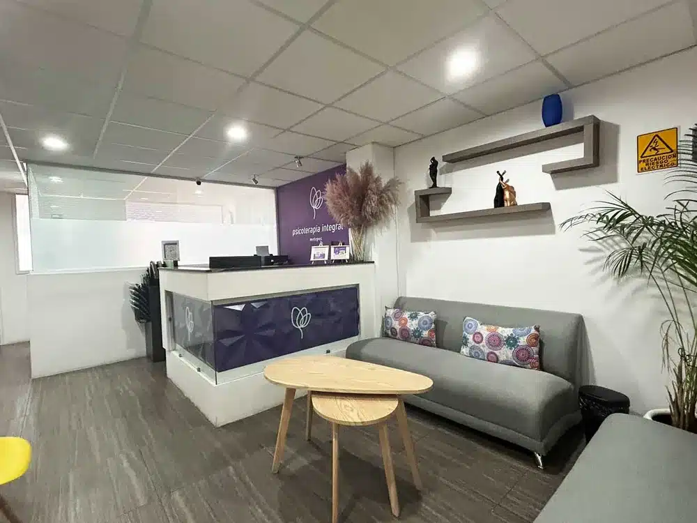 Recepción de Psicoterapia Integral Metepec, con el logotipo en una pared morada